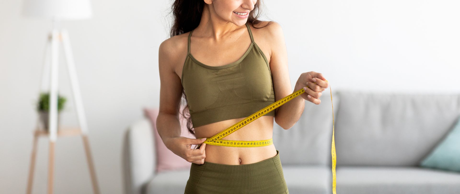 woman measuring waist living room